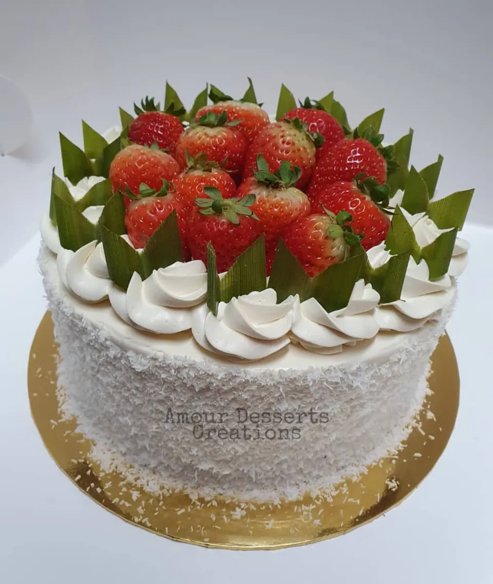 Pandan gula melaka cake by Amour Desserts topped with strawberries and pandan leaves